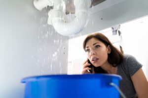 woman-watching-water-leak-from-pipe-under-sink