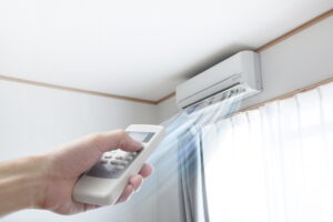 hand-with-remote-turning-on-ductless-air-handler