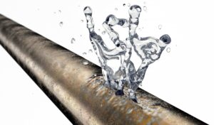 copper-plumbng-pipe-with-crack-in-it-and-water-splashing-out